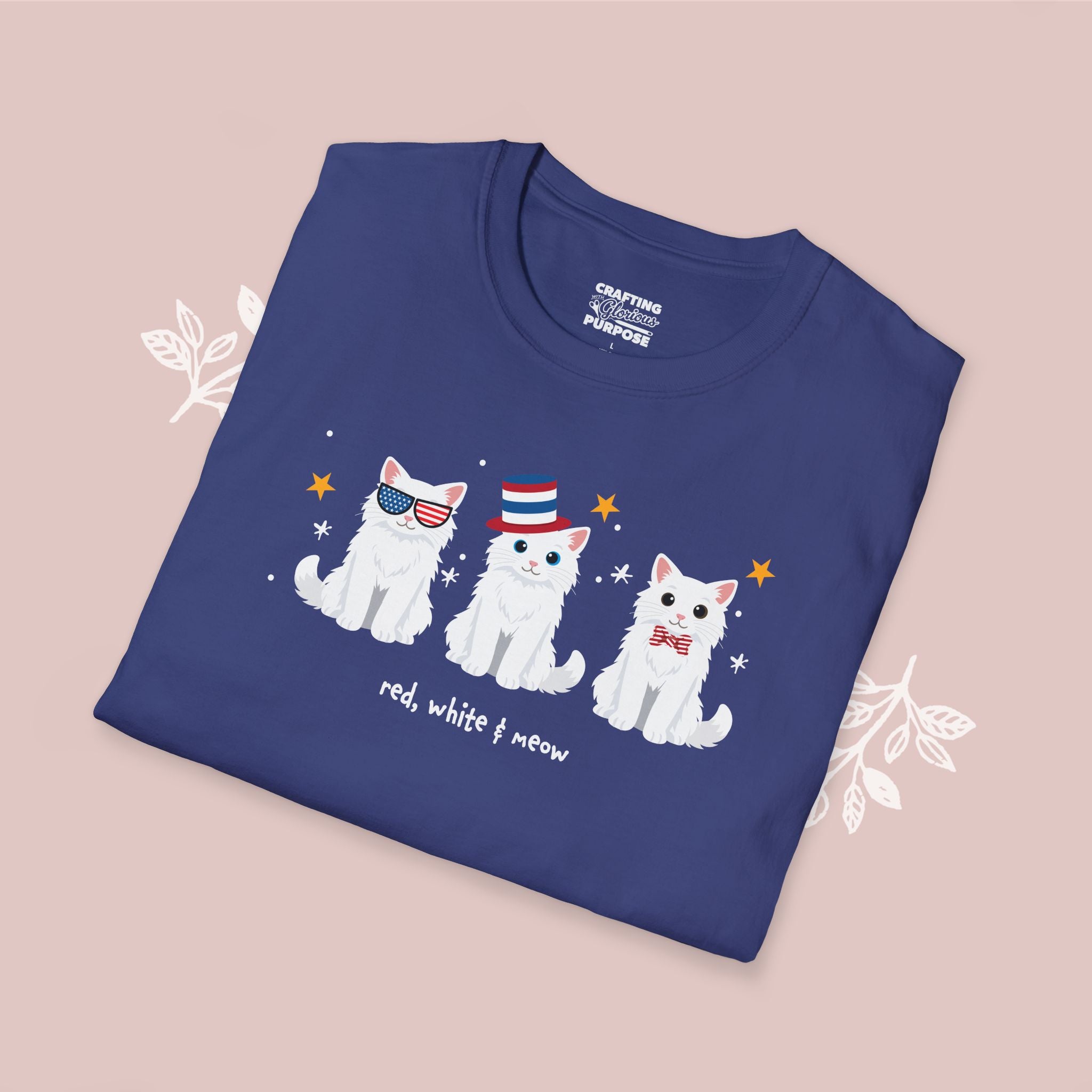 Folded blue t-shirt with white cat illustrations on a pink background