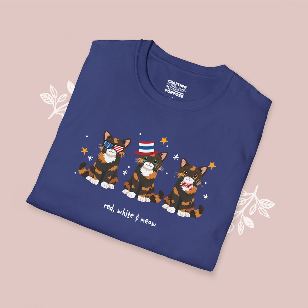 Folded blue t-shirt with cat illustrations and text on a beige background
