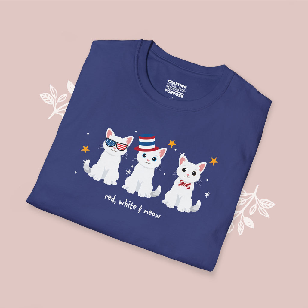 Folded blue t-shirt with cartoon cats design on a pink background