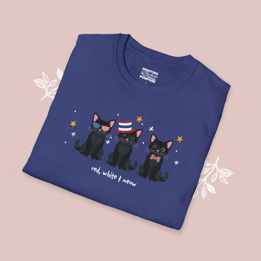 Folded blue t-shirt with black cats wearing American flag hats on a pink background