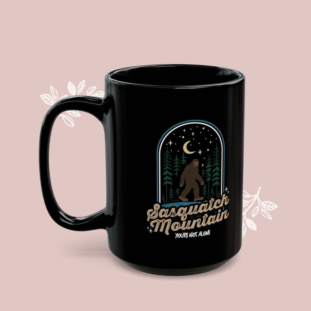 Sasquatch Mountain Black Mug — 'You're Not Alone' Retro Design