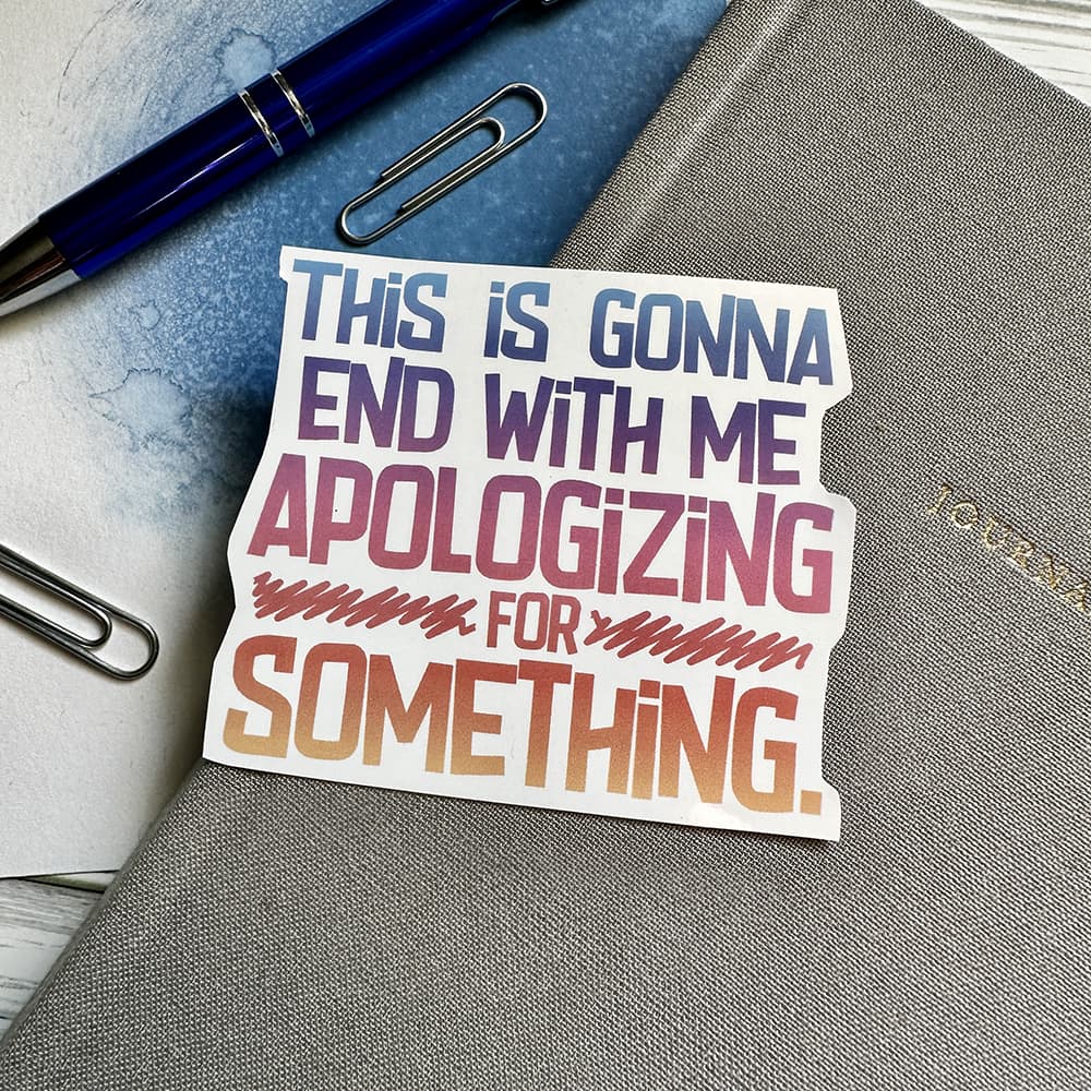 Sticker with text on a notebook with a pen and paper clips.