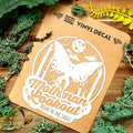 Vinyl decal of a mothman on a brown card with nature-themed elements.