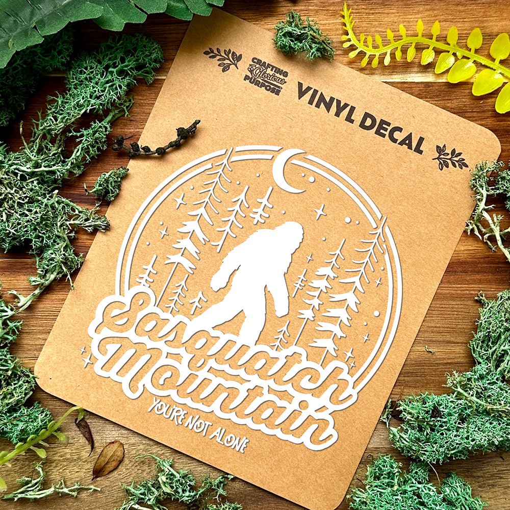 Vinyl decal for Sasquatch Mountain with nature-themed design on a wooden surface.