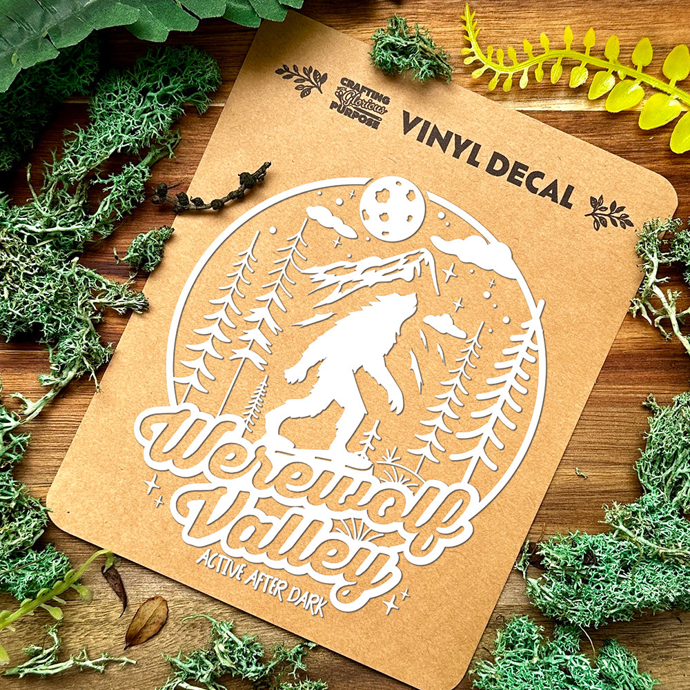 Vinyl decal of a werewolf with 'Werewolf Valley' text on a brown card, surrounded by green foliage.