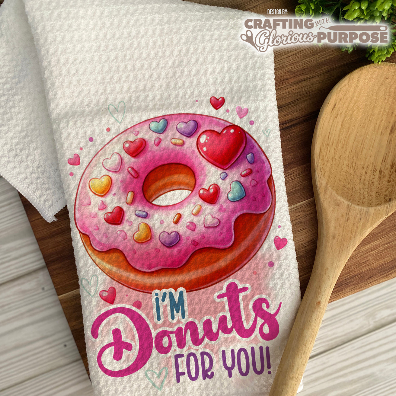 Kitchen towel with a donut design and text on a wooden surface