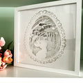 Framed paper cut art of a rabbit in a forest design on a light green background.