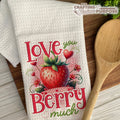 Decorative towel with strawberry design and text on a wooden surface