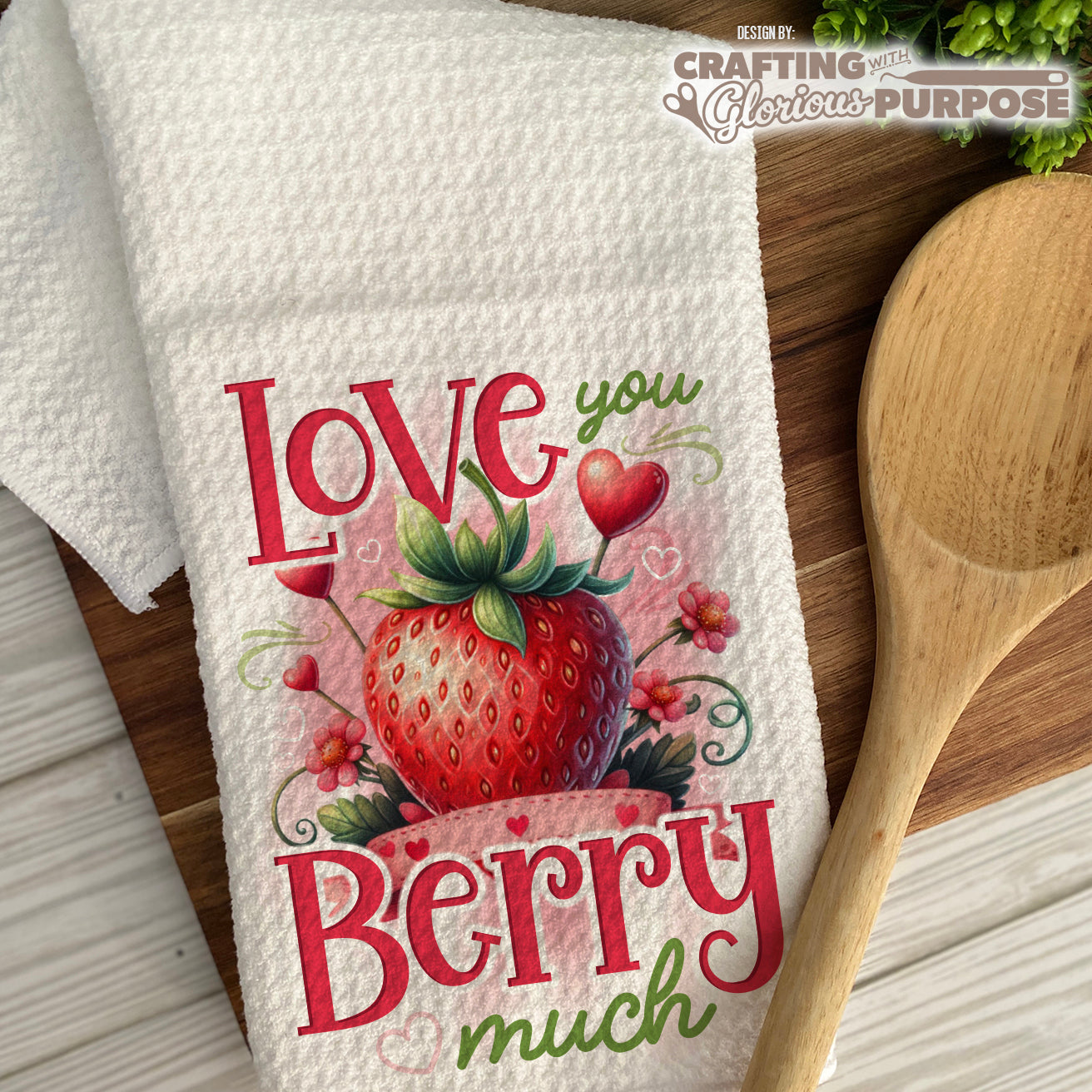 Decorative towel with strawberry design and text on a wooden surface