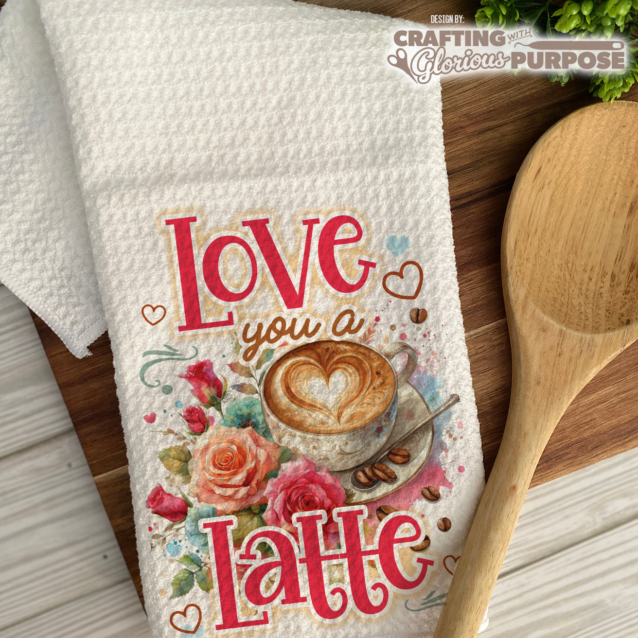 Kitchen towel with 'Love you a latte' design on a wooden surface with a wooden spoon.