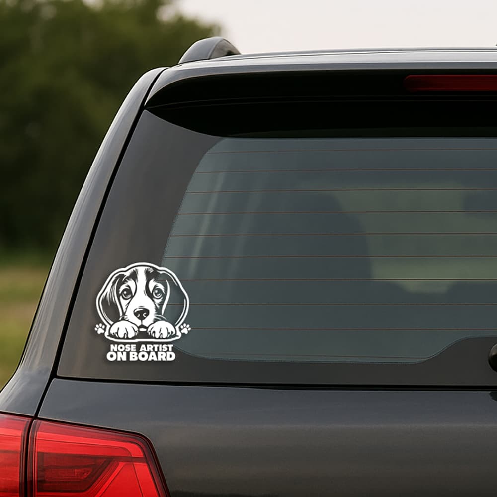 Car window with a dog-themed 'Nose Artist on Board' decal.