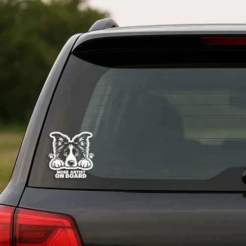 Car window with a dog-themed 'Nose Artist on Board' decal.