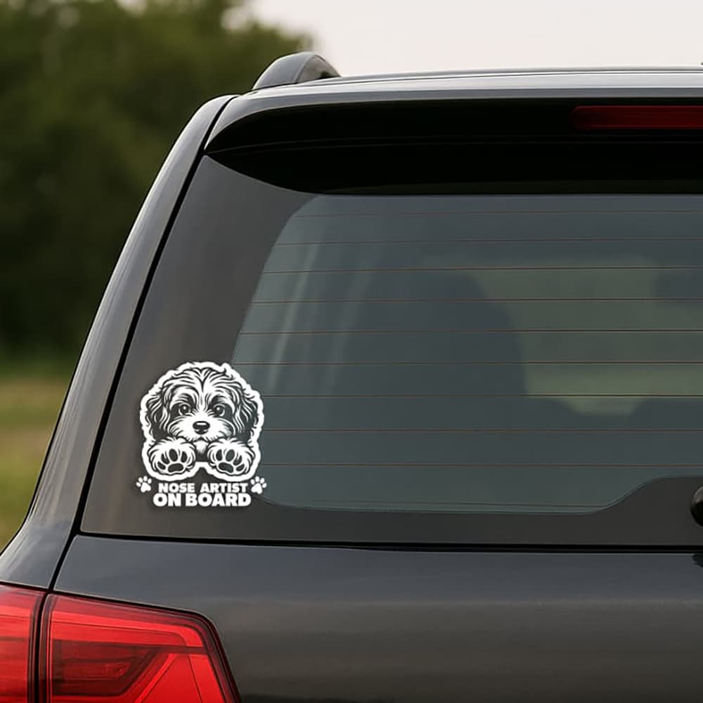 Car window with a dog-themed 'Nose Artist on Board' decal.