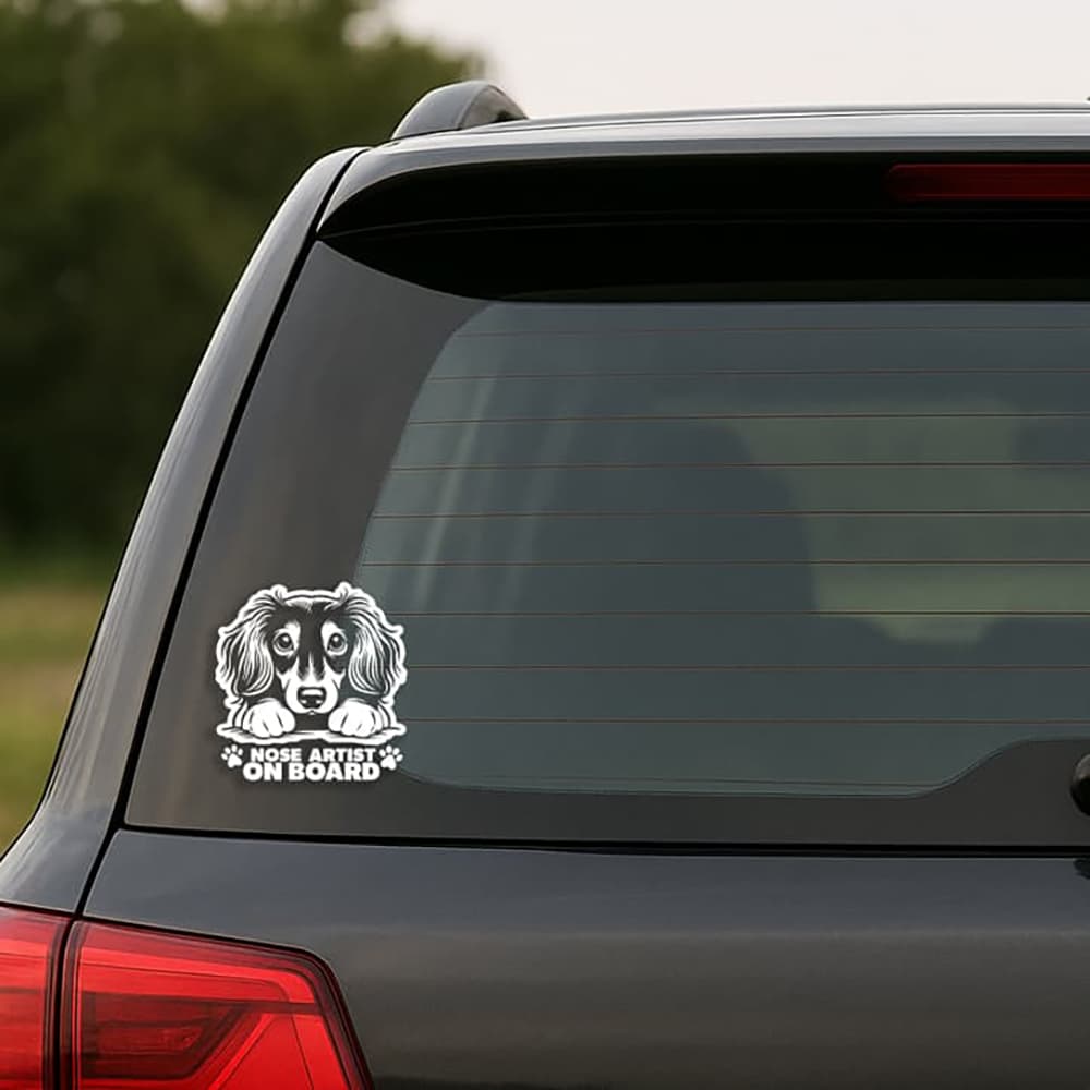 Car window with a dog-themed 'Nose Artist on Board' decal.