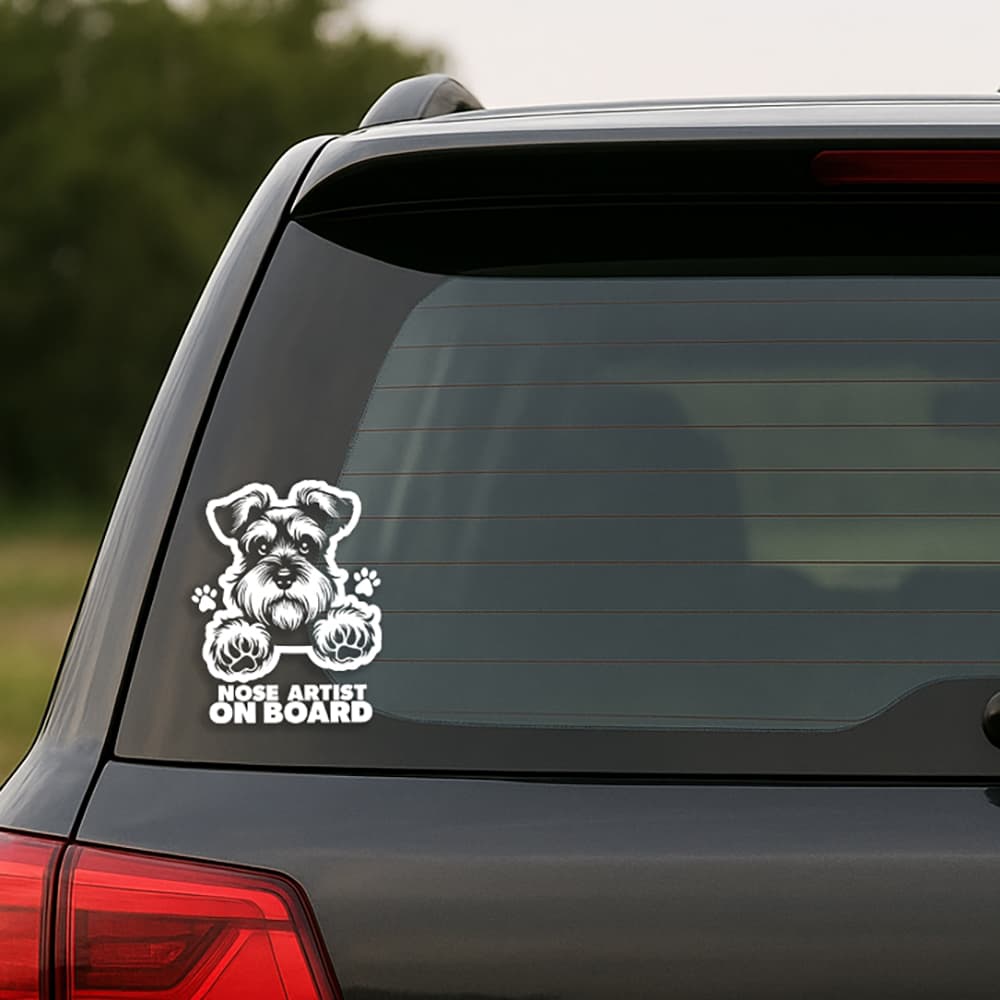 Car window with a dog-themed 'Nose Artist on Board' decal.