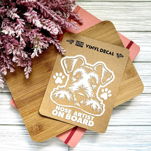 Vinyl decal with a dog illustration and text on a wooden surface with pink flowers.