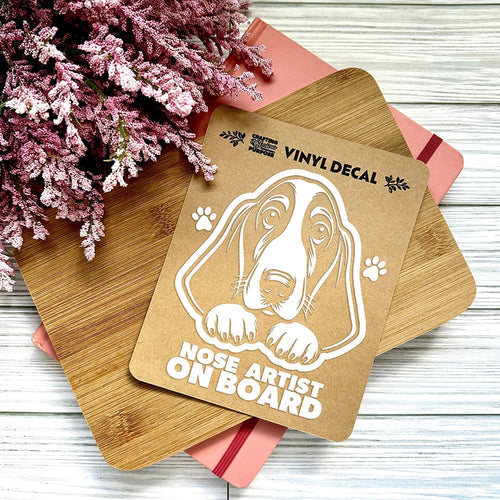 Vinyl decal with a dog illustration and text on a wooden surface with pink flowers.