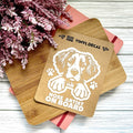 Vinyl decal with a dog design and text 'Nose Artist on Board' on a wooden surface with pink flowers.