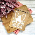 Vinyl decal with a dog illustration and text on a wooden surface with pink flowers.