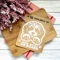 Vinyl decal with a dog illustration and text on a wooden surface with pink flowers.