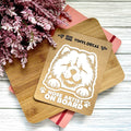 Vinyl decal with a dog illustration and text on a wooden surface with pink flowers.
