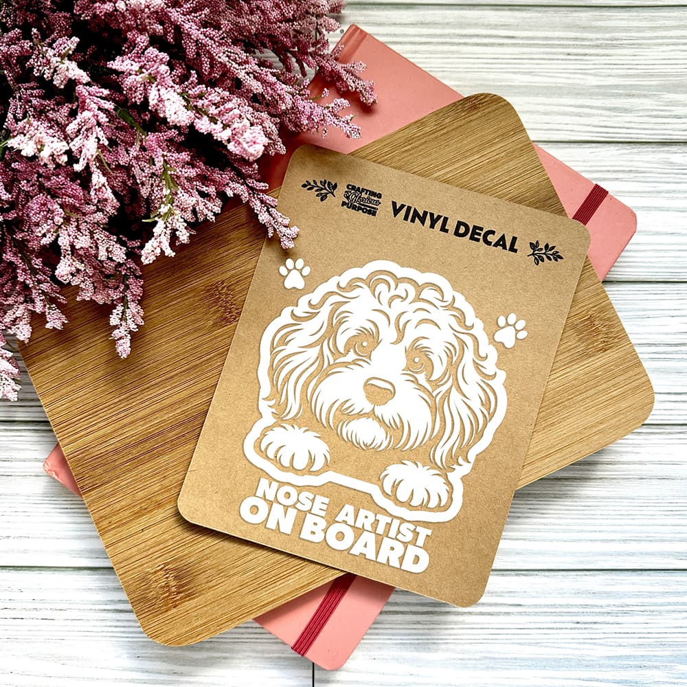 Vinyl decal with a dog illustration and text on a wooden surface with pink flowers.