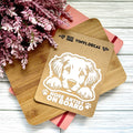 Vinyl decal with a dog illustration and text on a wooden surface with pink flowers.