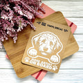 Vinyl decal with a dog illustration and text on a wooden board with pink flowers in the background.