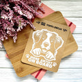 Vinyl decal with a dog illustration and text on a wooden surface with pink flowers.