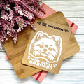 Vinyl decal with a dog illustration and text on a wooden surface with pink flowers.