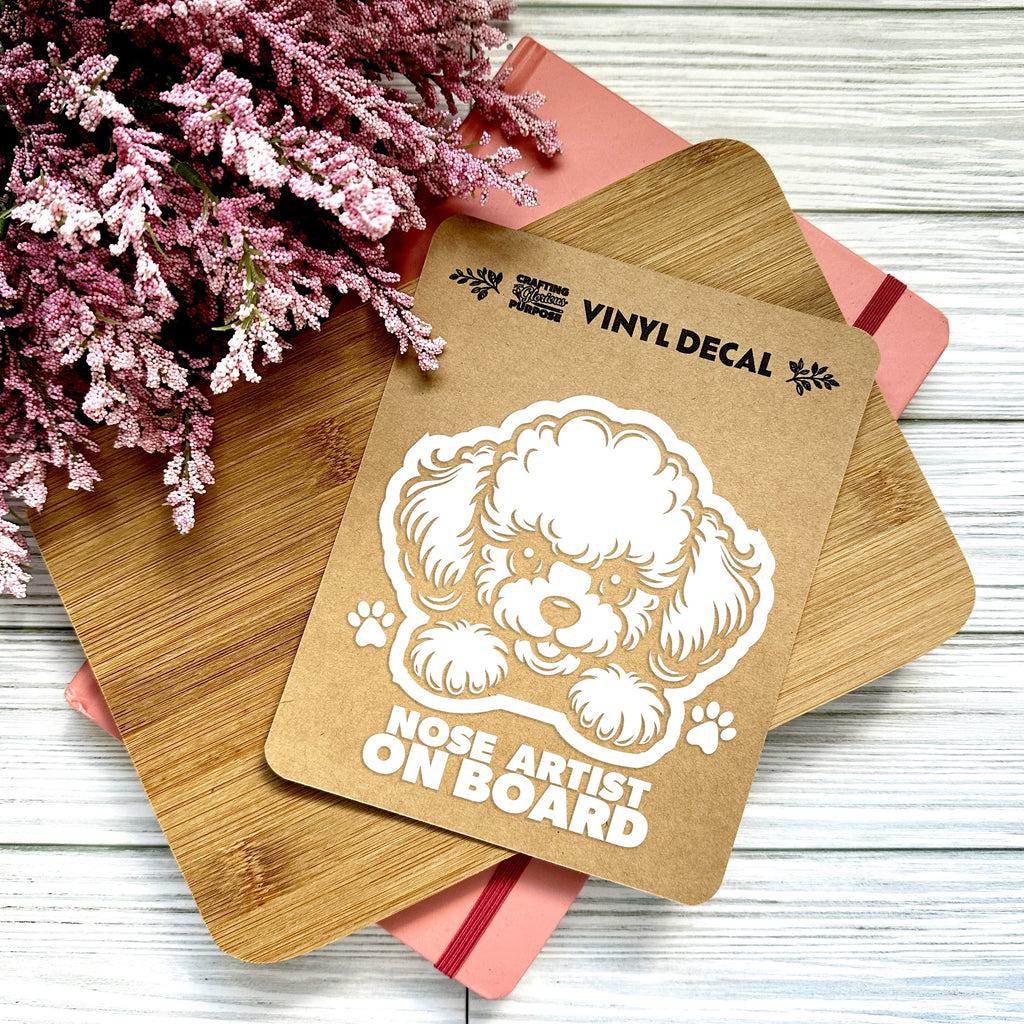 Vinyl decal with a dog illustration and text on a wooden surface with pink flowers.
