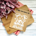 Vinyl decal with a dog illustration and text on a wooden surface with pink flowers.