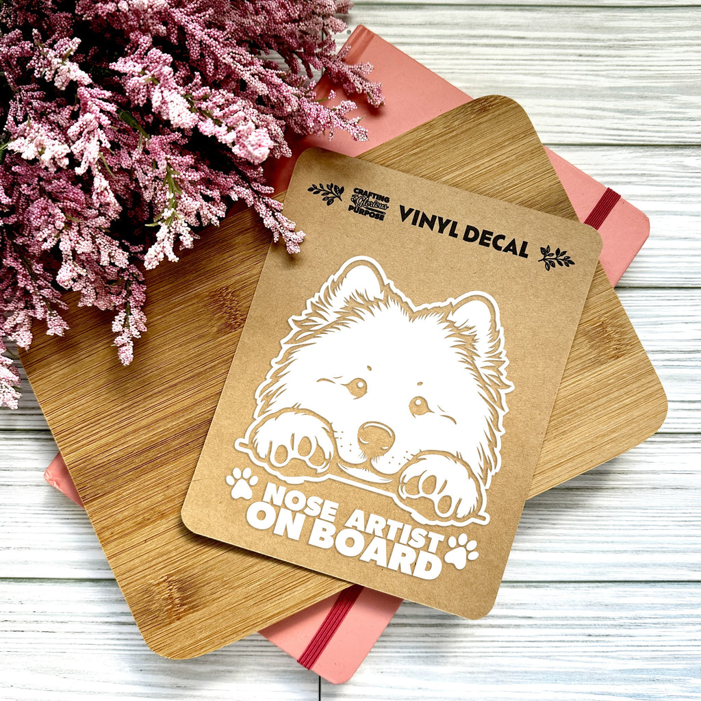 Vinyl decal with a dog illustration and text on a wooden surface with pink flowers.