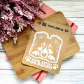 Vinyl decal with a dog illustration and text on a wooden surface with pink flowers.