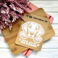 Vinyl decal with a dog illustration and text on a wooden surface with pink flowers.