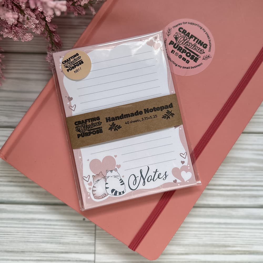 Handmade notepad with decorative design on a pink surface