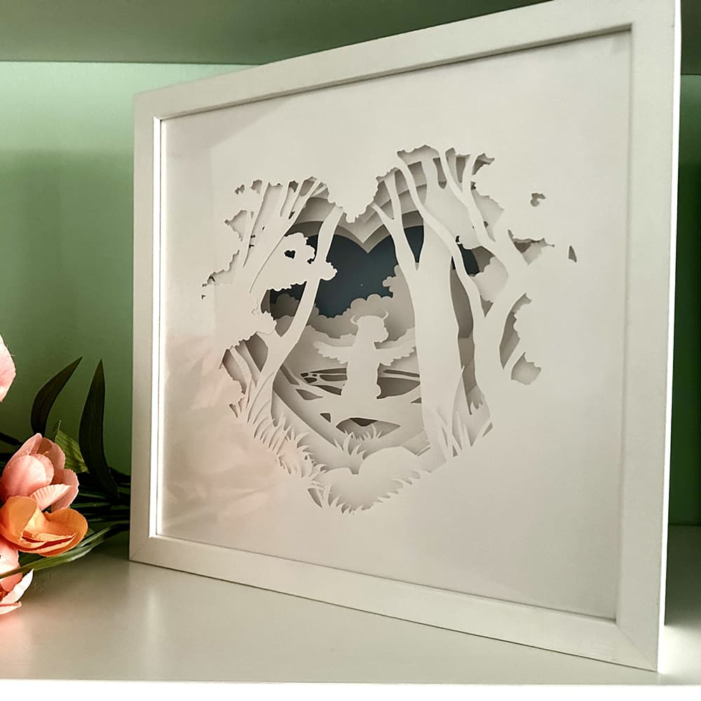 Framed paper cut art of a dog in a forest frame