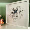 Framed paper cut art of a dog in a forest frame