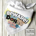 White bandana with colorful text and a puppy graphic on a wooden surface.