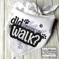 White bandana with text 'did someone say walk?' on a wooden surface