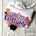 White bandana with 'I Ate My Costume' text and Halloween-themed design on a wooden surface.
