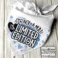 White bandana with text 'I'm not a mutt, I'm limited edition' on a wooden surface.