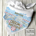 White bandana with festive design and text on a wooden surface