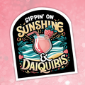 Sticker with 'Sippin' on Sunshine & Daiquis' design on a pink background