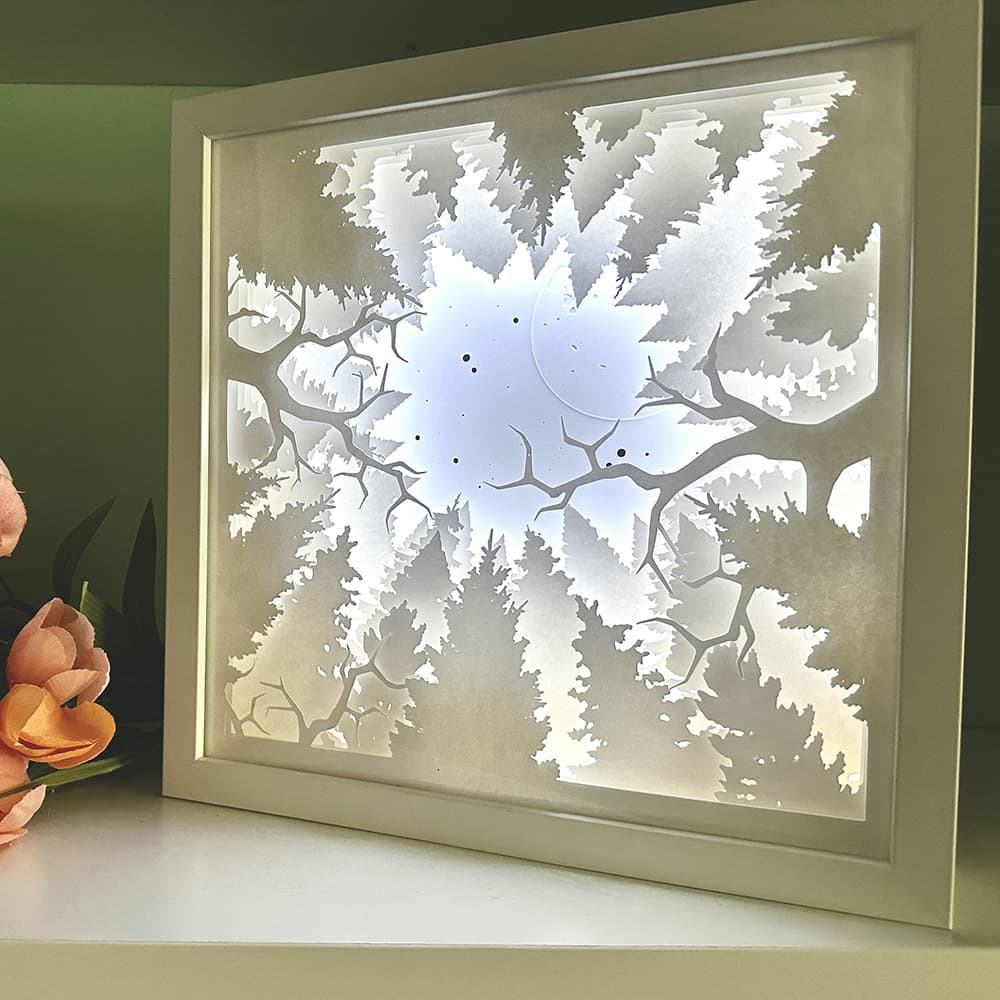 Framed artwork of a tree design on a white surface with a green background
