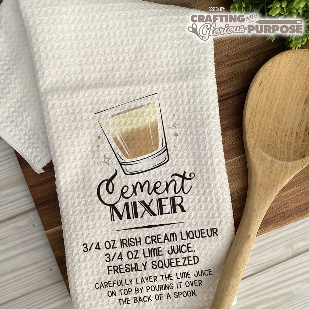 White towel with 'Cement Mixer' recipe graphic and wooden spoon on a wooden surface