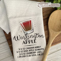 Dish towel with cocktail recipe and wooden spoon on a wooden surface