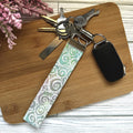 Keychain with a patterned strap on a wooden surface