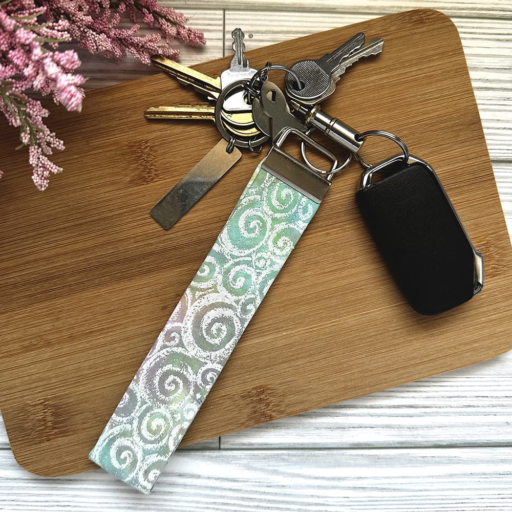 Keychain with a patterned strap on a wooden surface