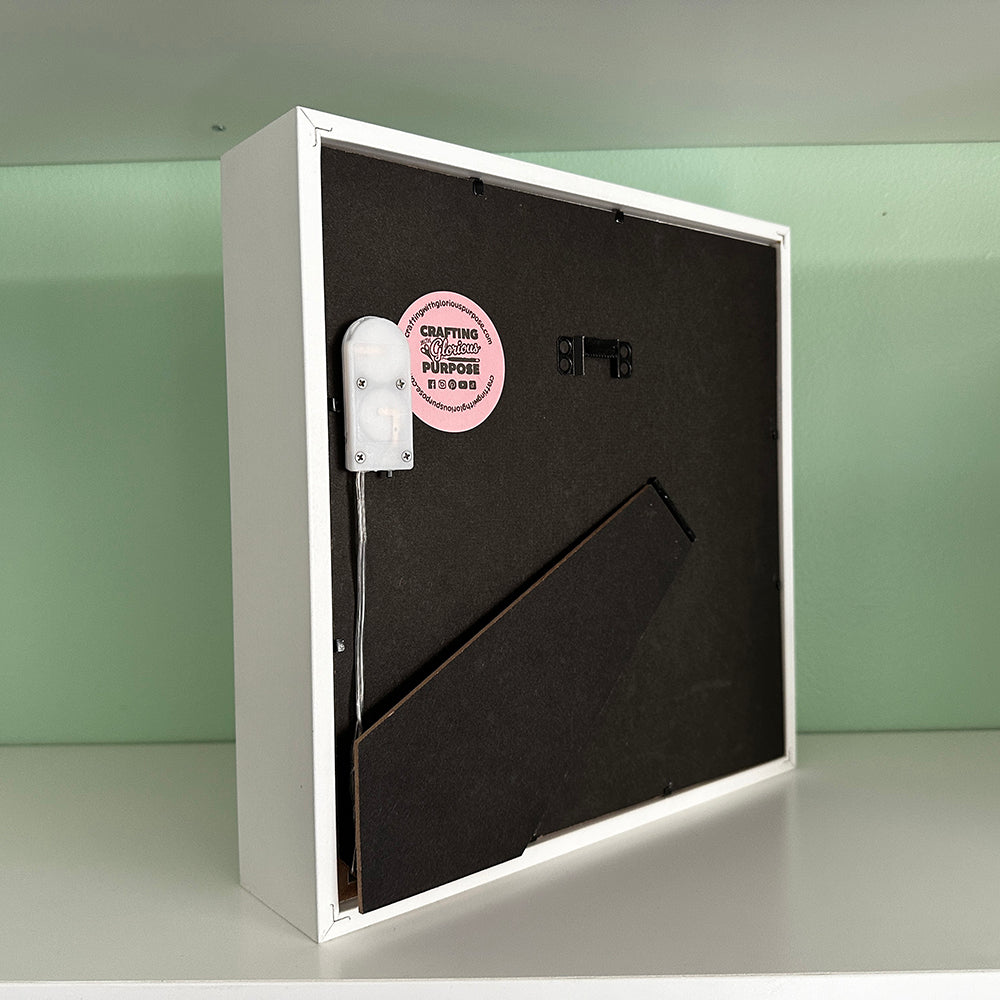 White box with a black interior on a light green background